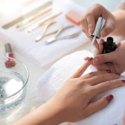 close up image of woman having her nails done in beauty salon